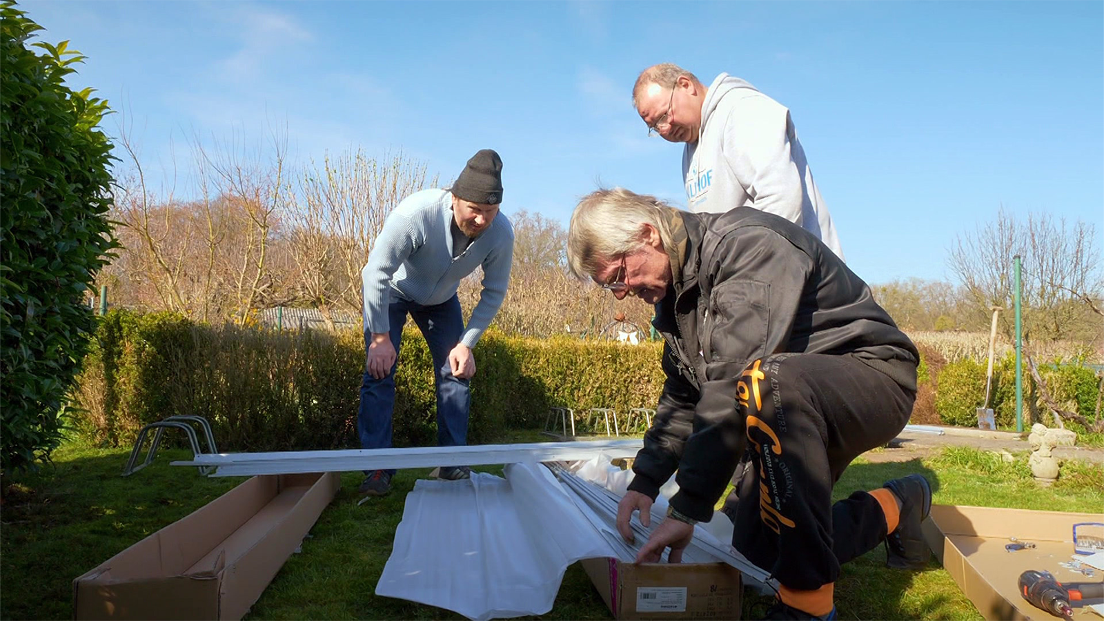 Wendelin (li.), Jürgen und Uwe macht der Aufbau eines Gewächshauses zu schaffen.